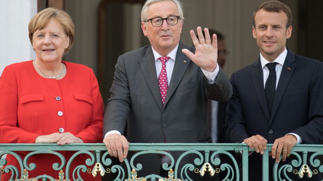 EU-KommissionsprÃ¤sident Jean-Claude Juncker mit Bundeskanzlerin Angela Merkel und Frankreichs PrÃ¤sident Emmanuel Macron auf dem Balkon von Schloss Meseberg 
