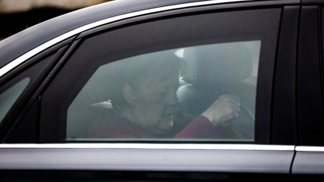 Angela Merkel hinter dem Fenster eines Autos